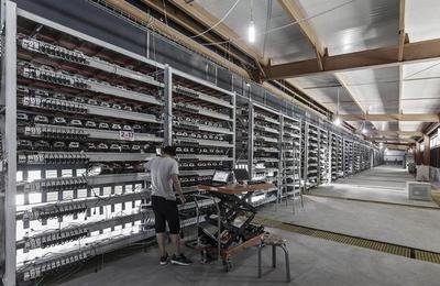 Large-scale cryptocurrency mining farm with rows of mining rigs